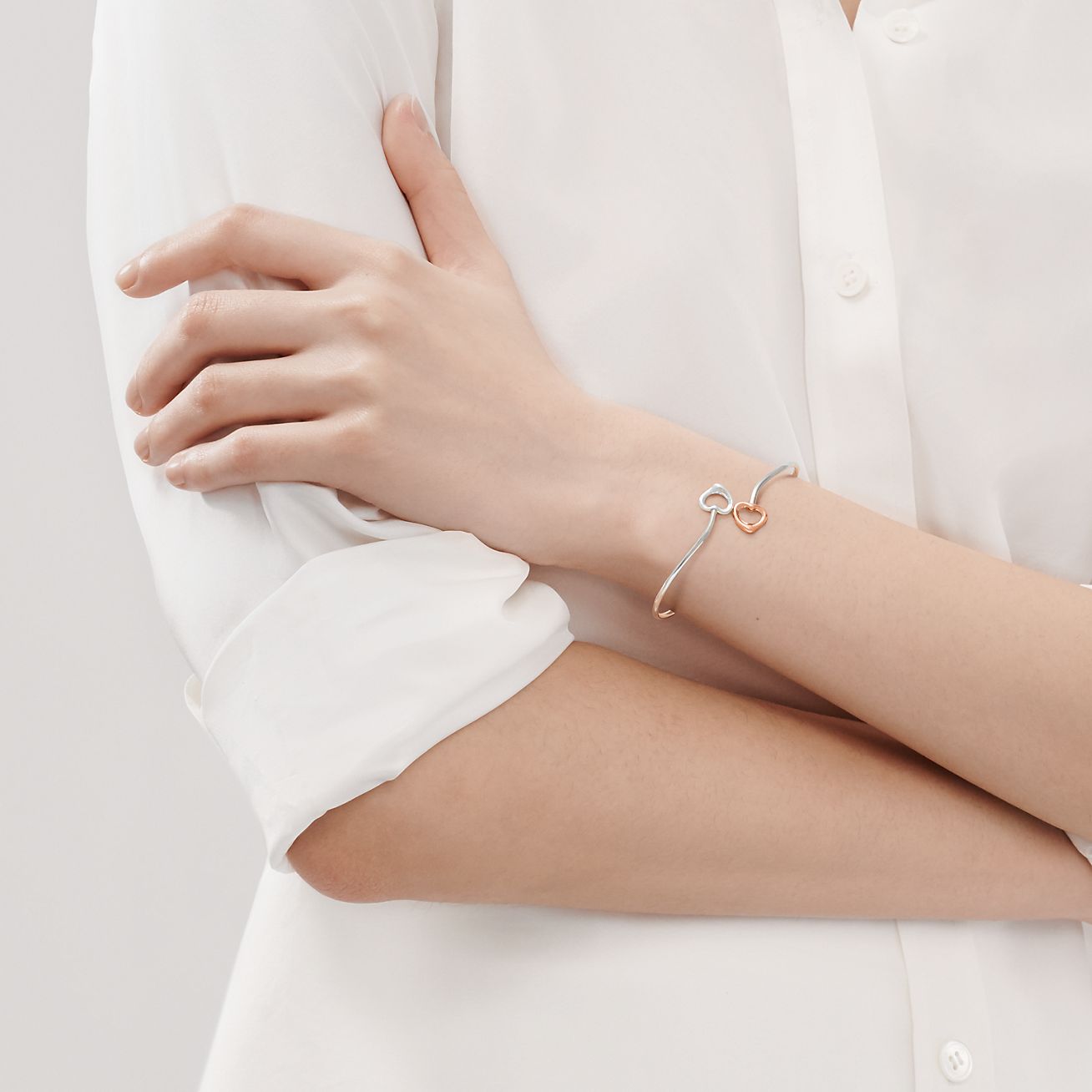 Elsa Peretti® Double Open Heart bangle in silver and 18k rose gold, medium.  | Tiffany & Co.