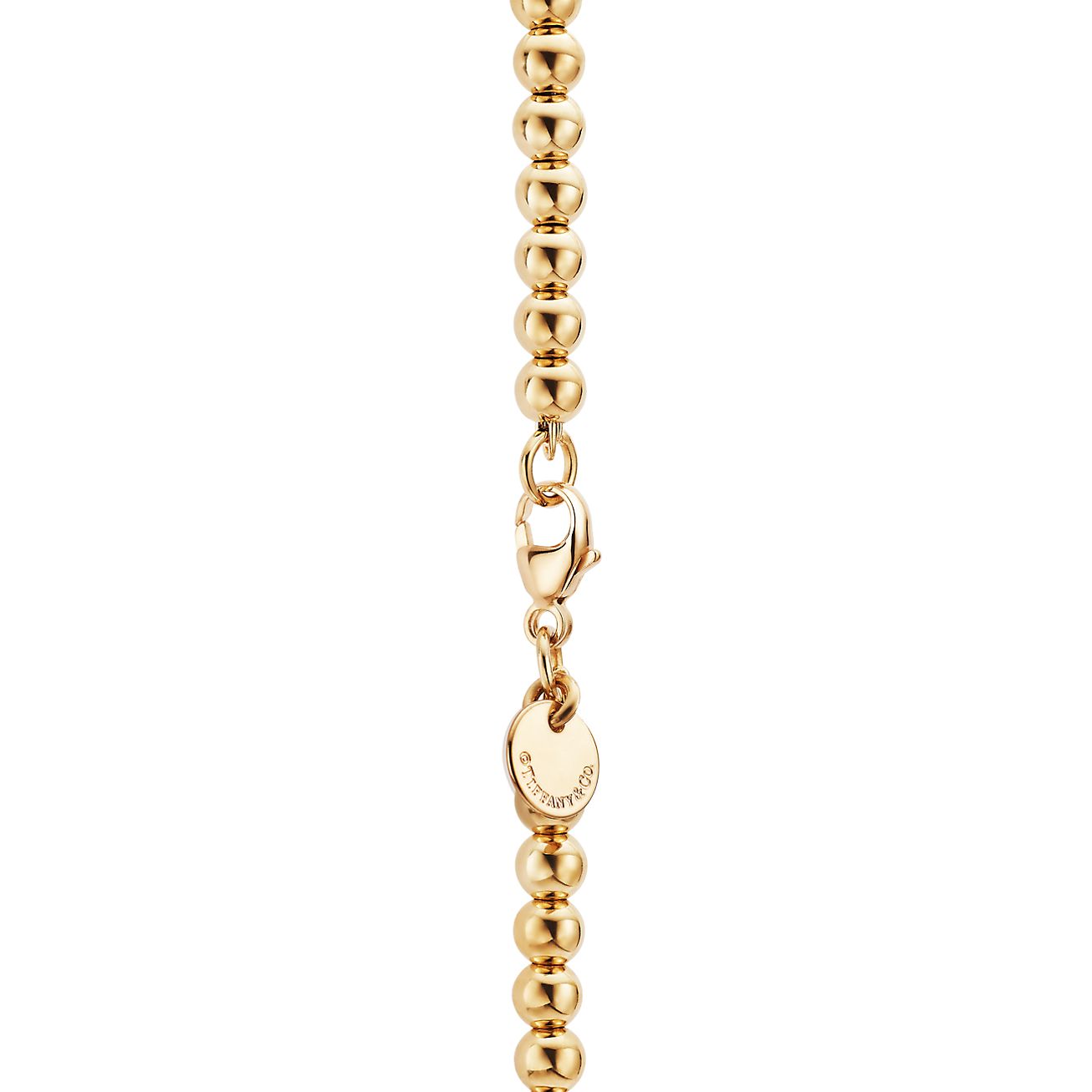 Return to Tiffany mini heart tag on a bead bracelet in 18k gold medium. Tiffany Co. CA
