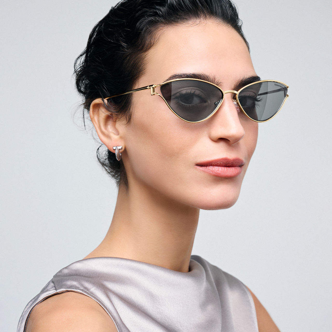 Sonnenbrille aus blassgoldfarbenem Metall mit dunkelgrauen Gläsern