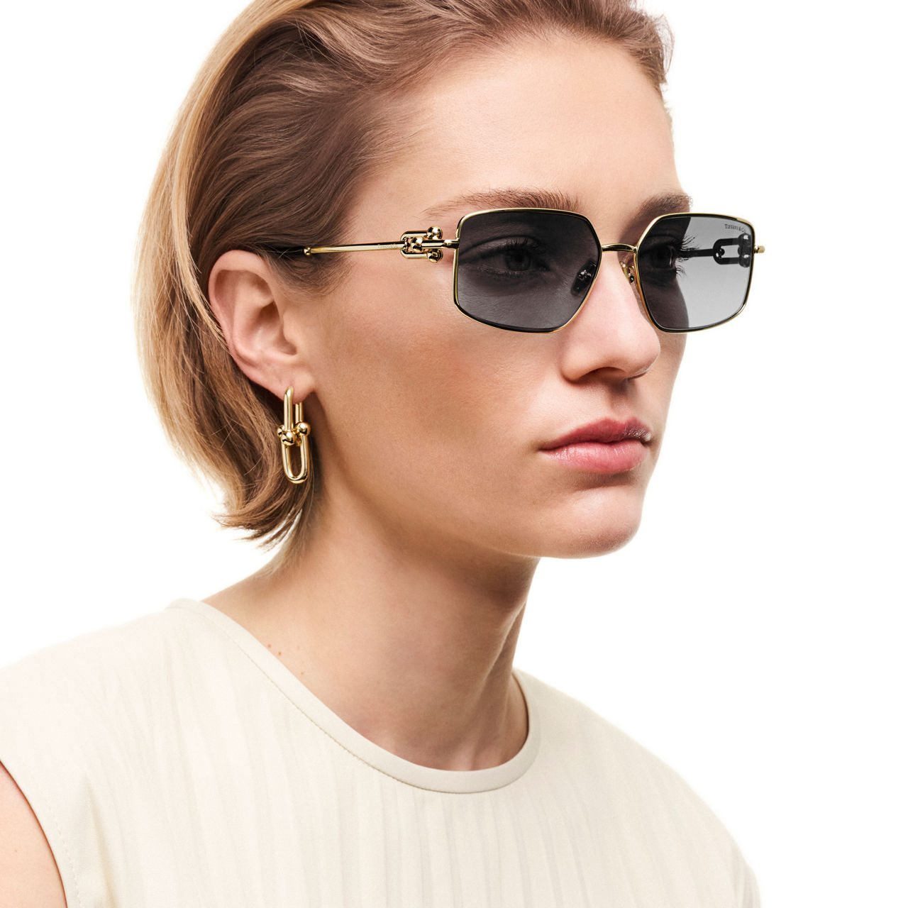Sonnenbrille aus blassgoldenem Metall mit dunkelgrauen Gläsern